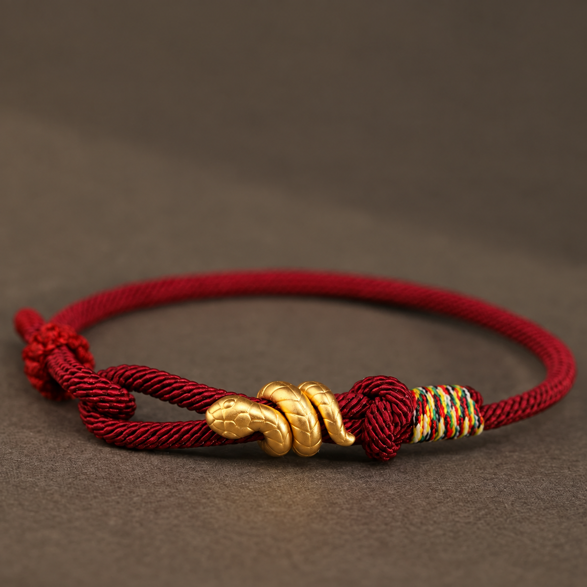 Snake motif bracelet with red, bright red, or black braided cord