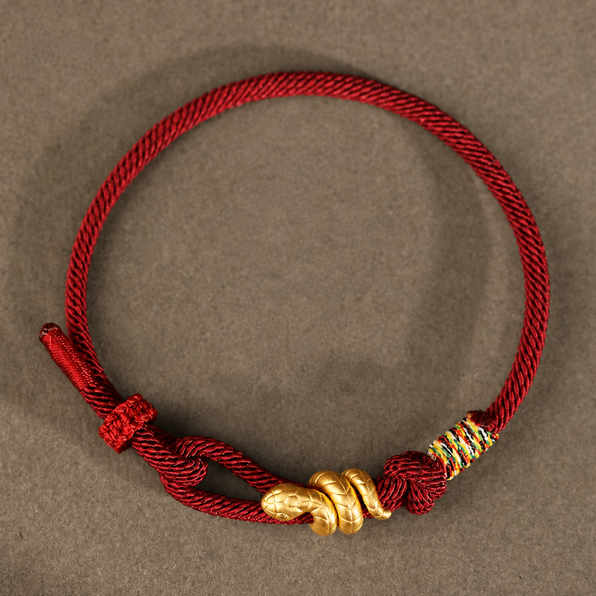 Snake motif bracelet with red, bright red, or black braided cord