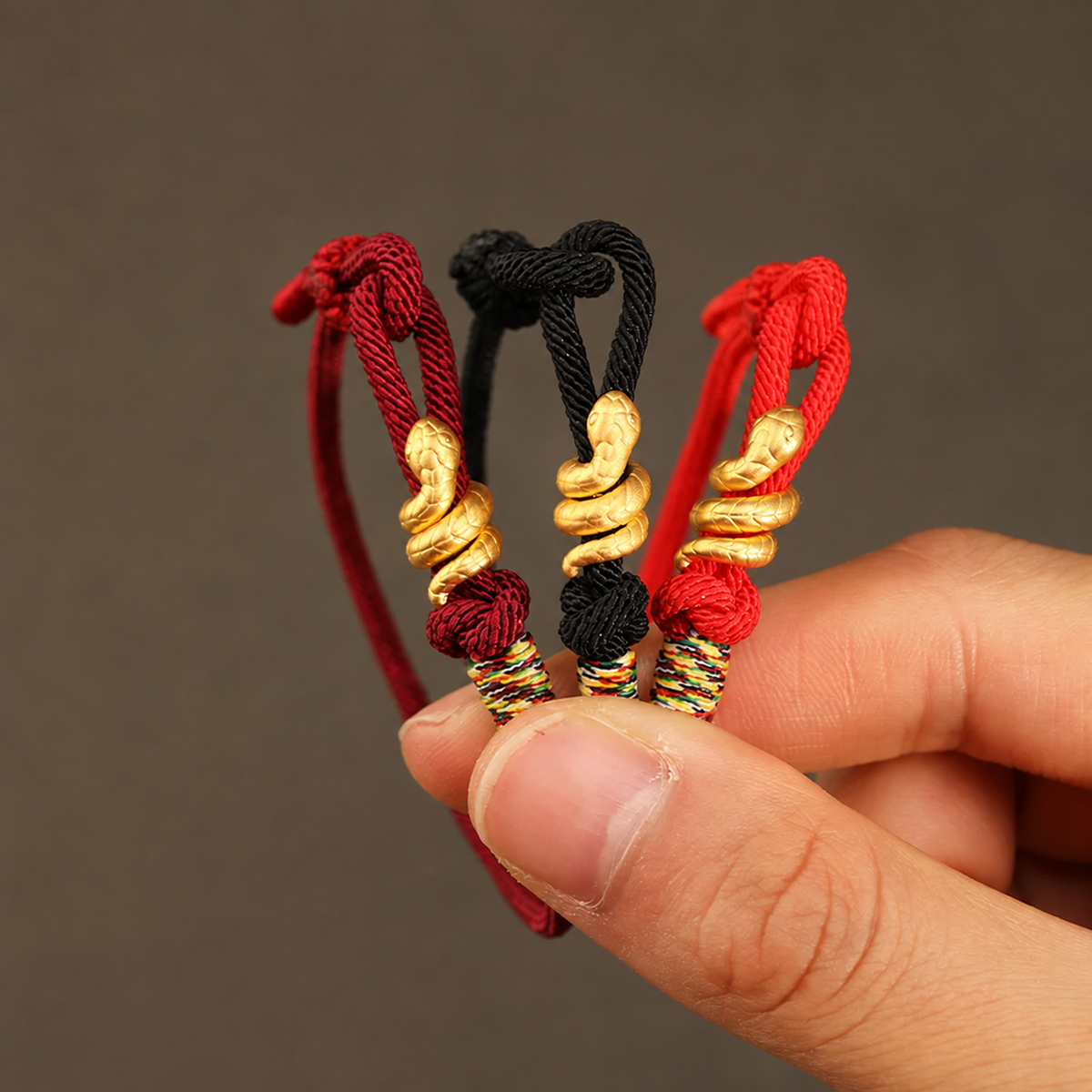 Snake motif bracelet with red, bright red, or black braided cord