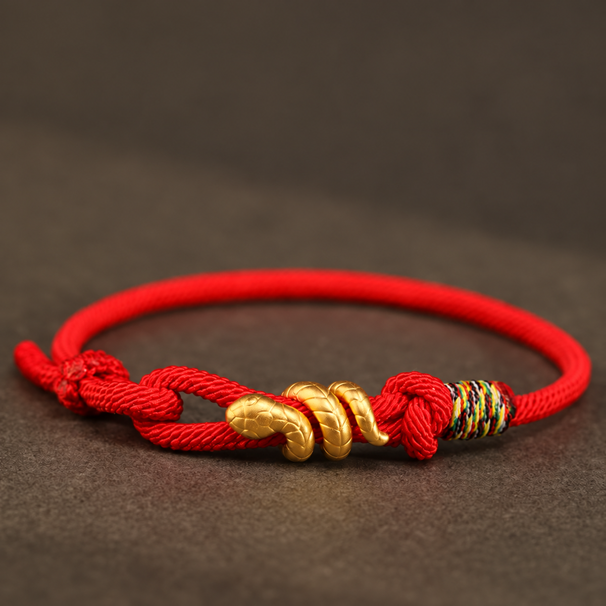 Snake motif bracelet with red, bright red, or black braided cord